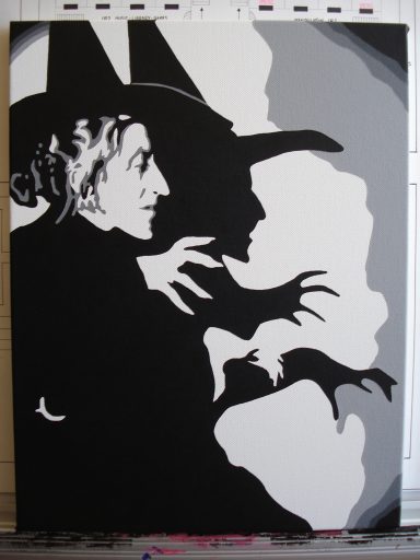A silhouette of a witch with pointed hat and outstretched hands in black and white.